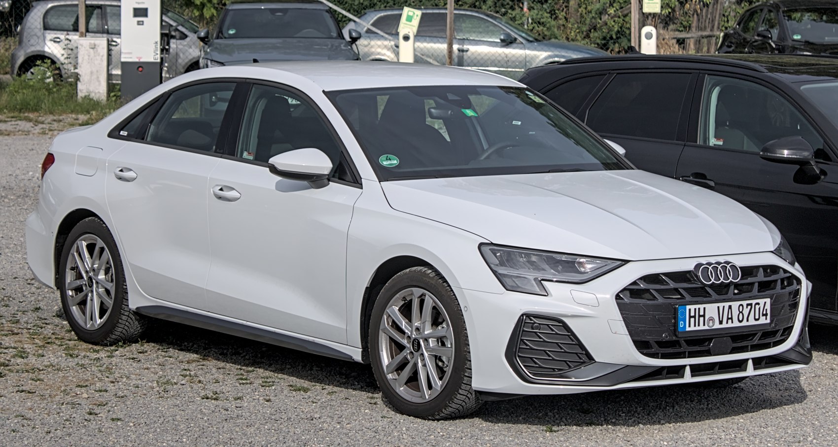 White modern sedan with sporty black grille and alloy wheels