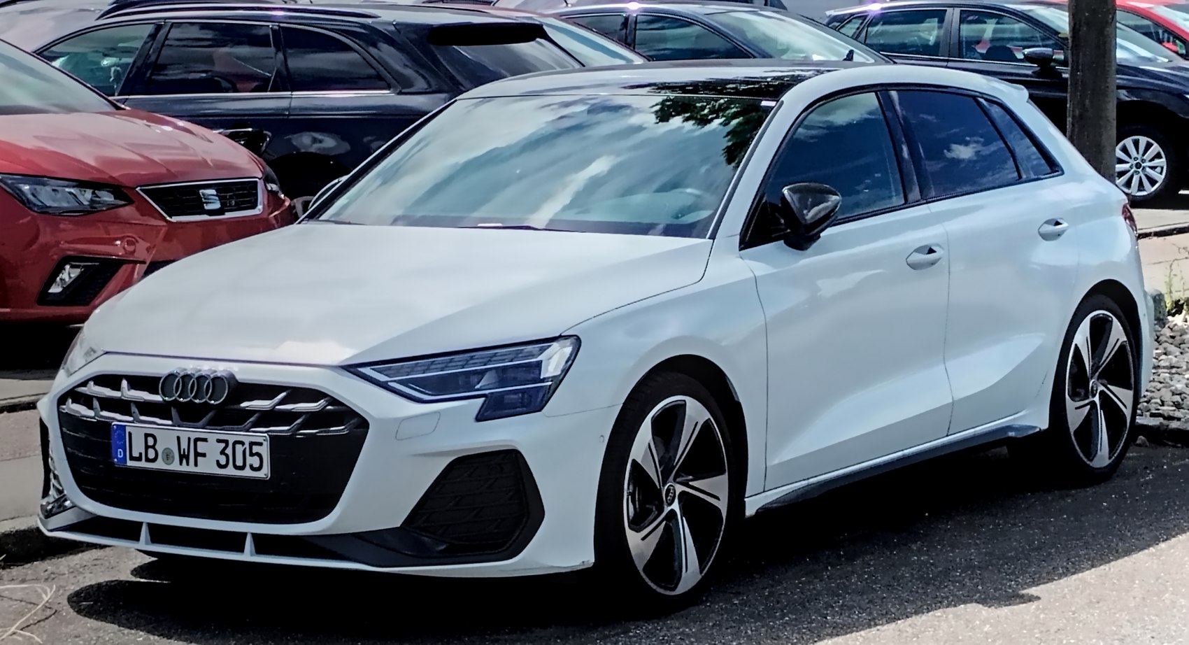 White hatchback with modern headlights and sporty alloy wheels