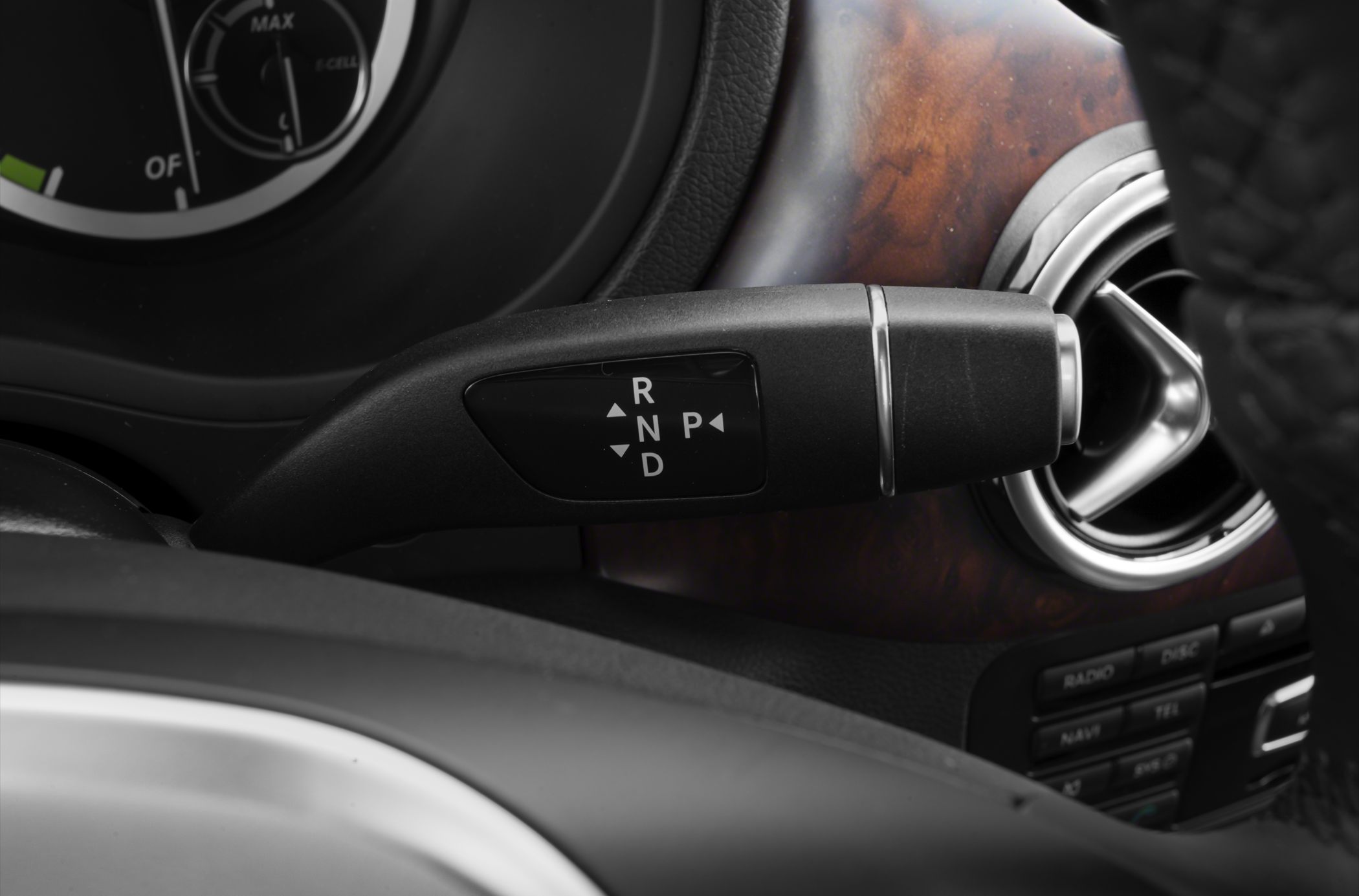 Close-up of gear selector lever with dashboard and air vent.