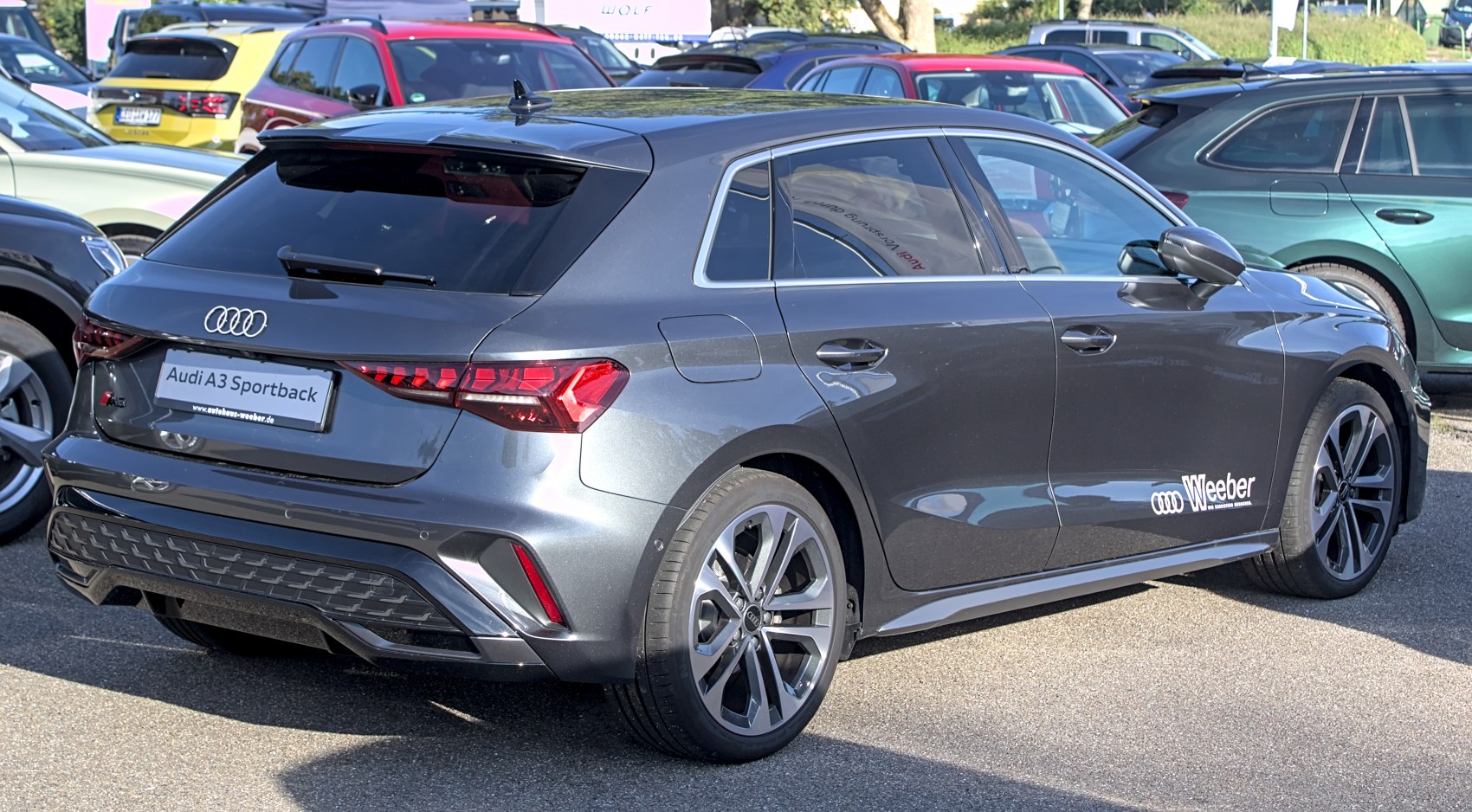 Rear and side view of a dark gray hatchback with sleek tail lights and alloy wheels