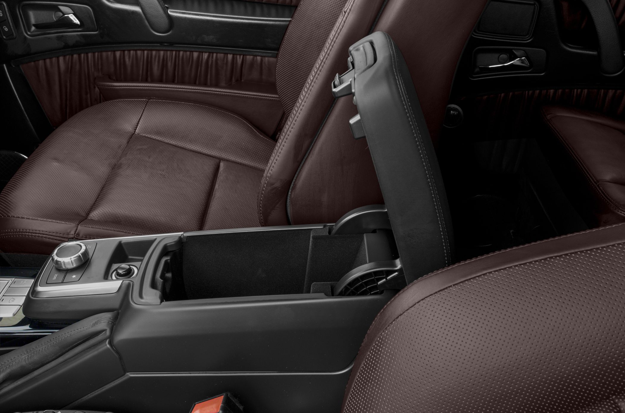 Close-up of perforated leather seats and center armrest storage compartment.