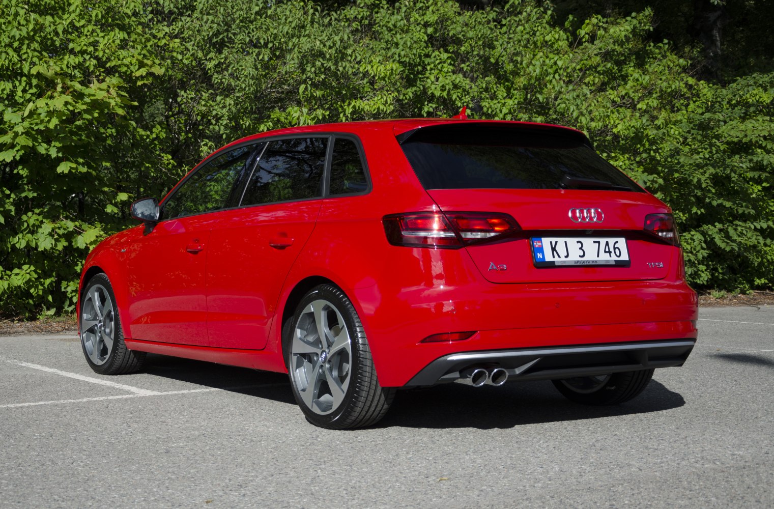 Red hatchback rear view with dual exhaust and tinted windows