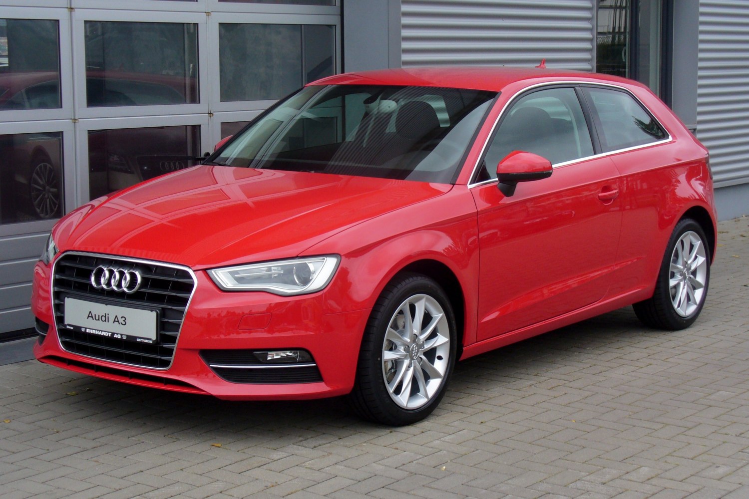 Red compact hatchback with front-side view, alloy wheels, and modern headlights