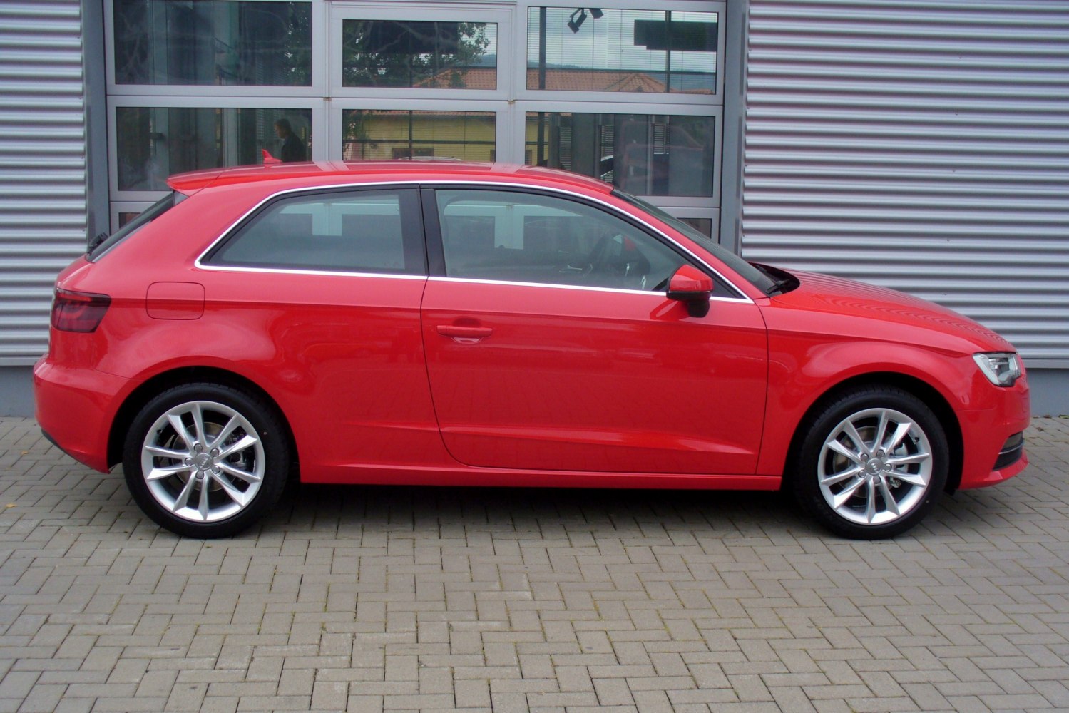 Red 3-door hatchback with alloy wheels side profile