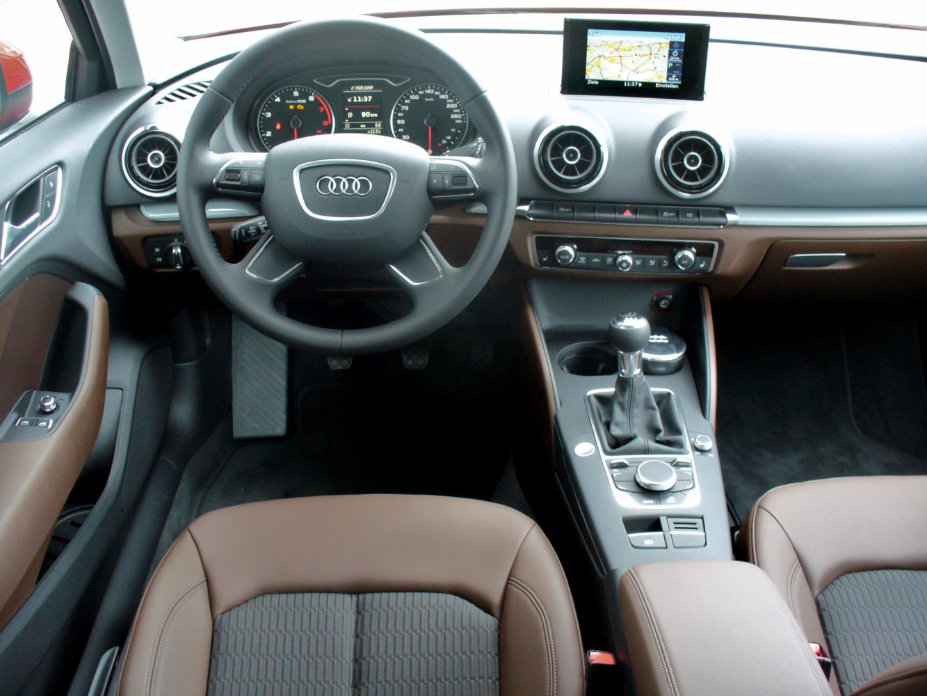 Steering wheel, dashboard, manual gear shift, infotainment screen, round air vents