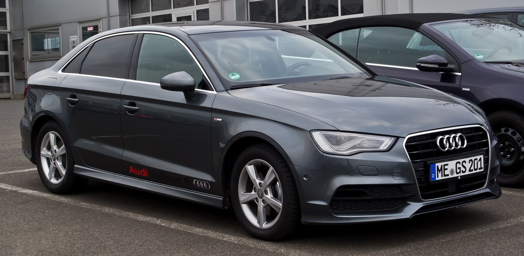 Front side view of a grey sedan with alloy wheels