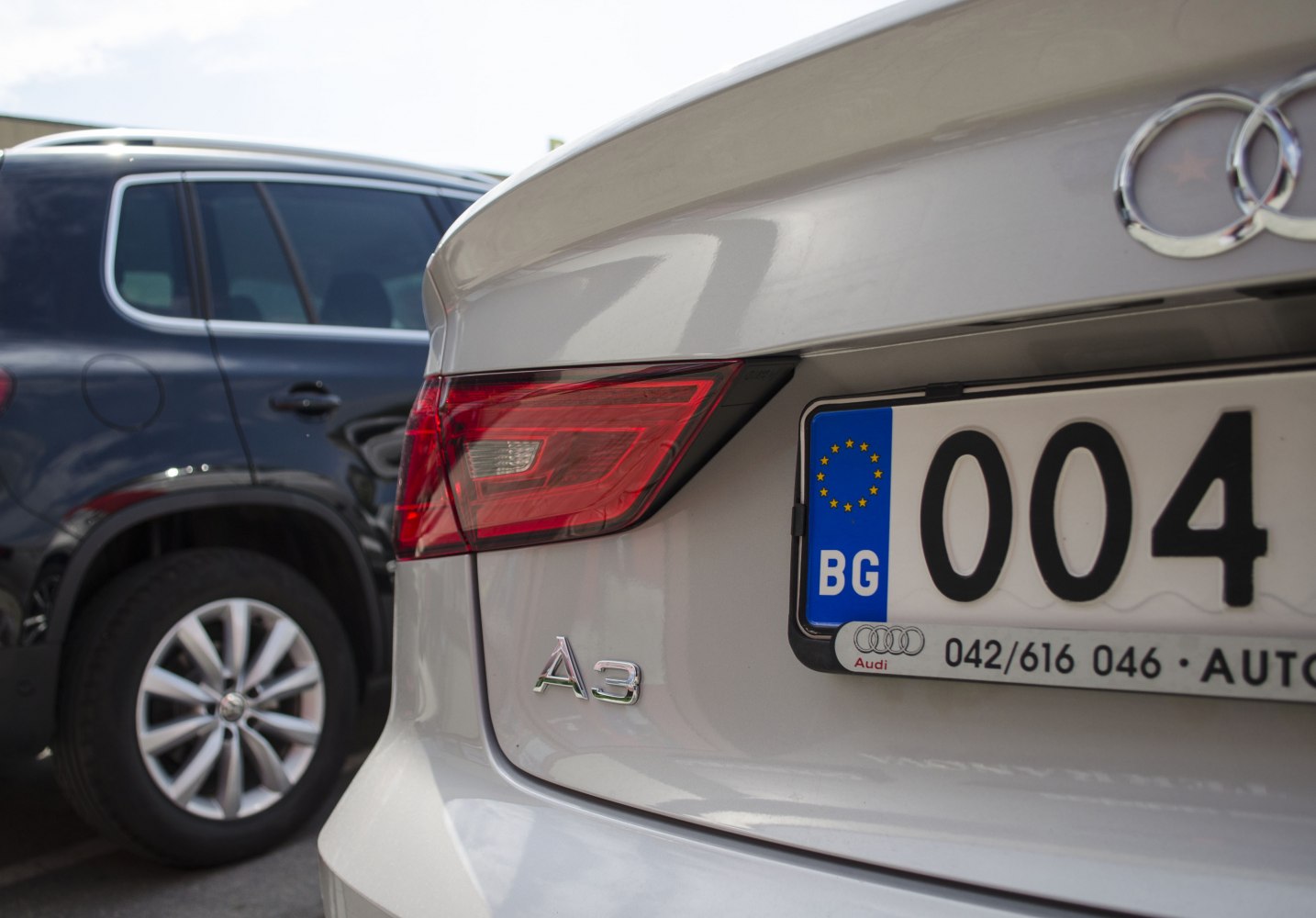Close-up of a rear tail light, badge, and license plate on a vehicle