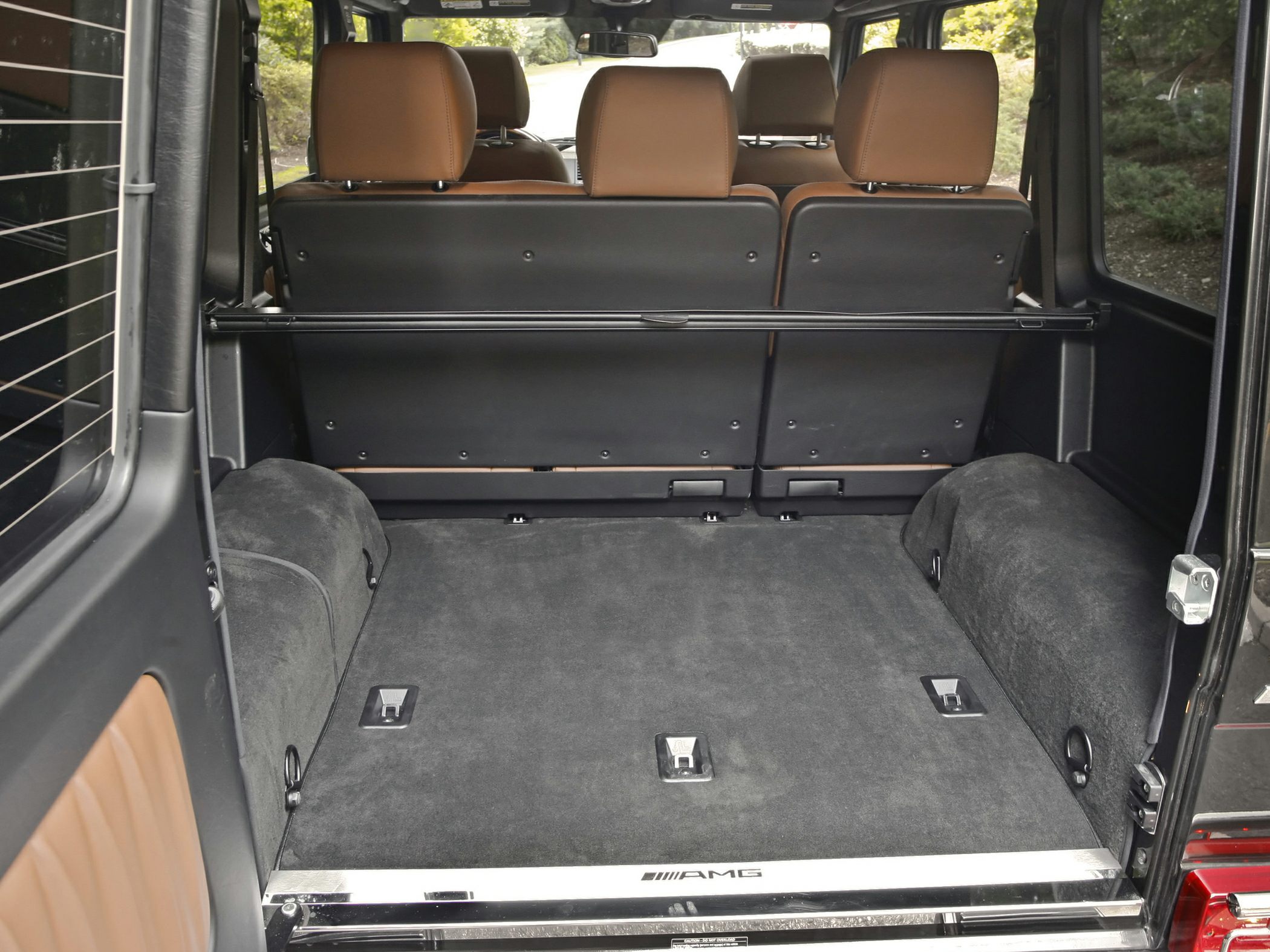 Spacious carpeted rear cargo area with AMG logo and brown leather seatbacks