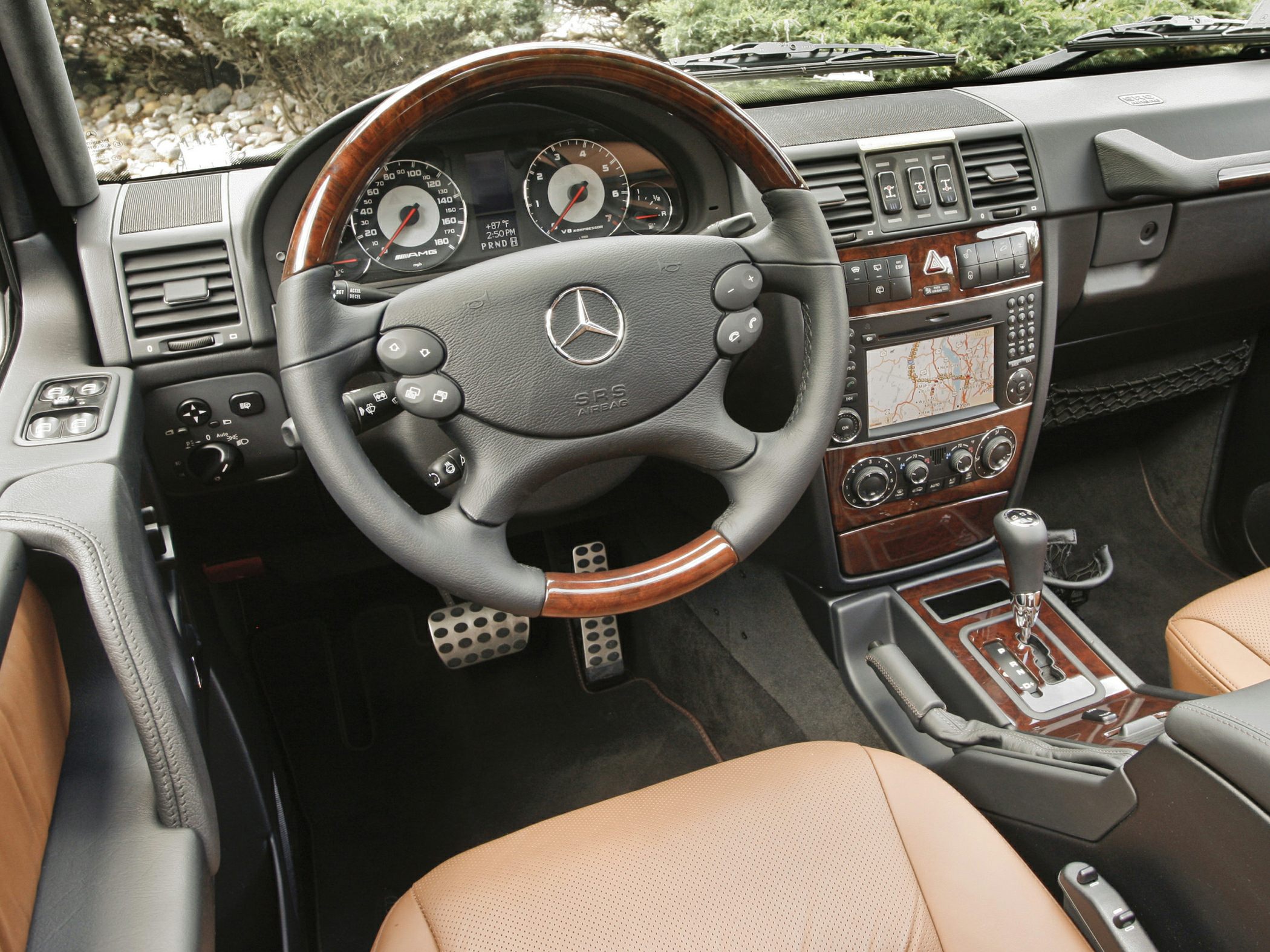 Dashboard and steering wheel with wood trim and navigation screen
