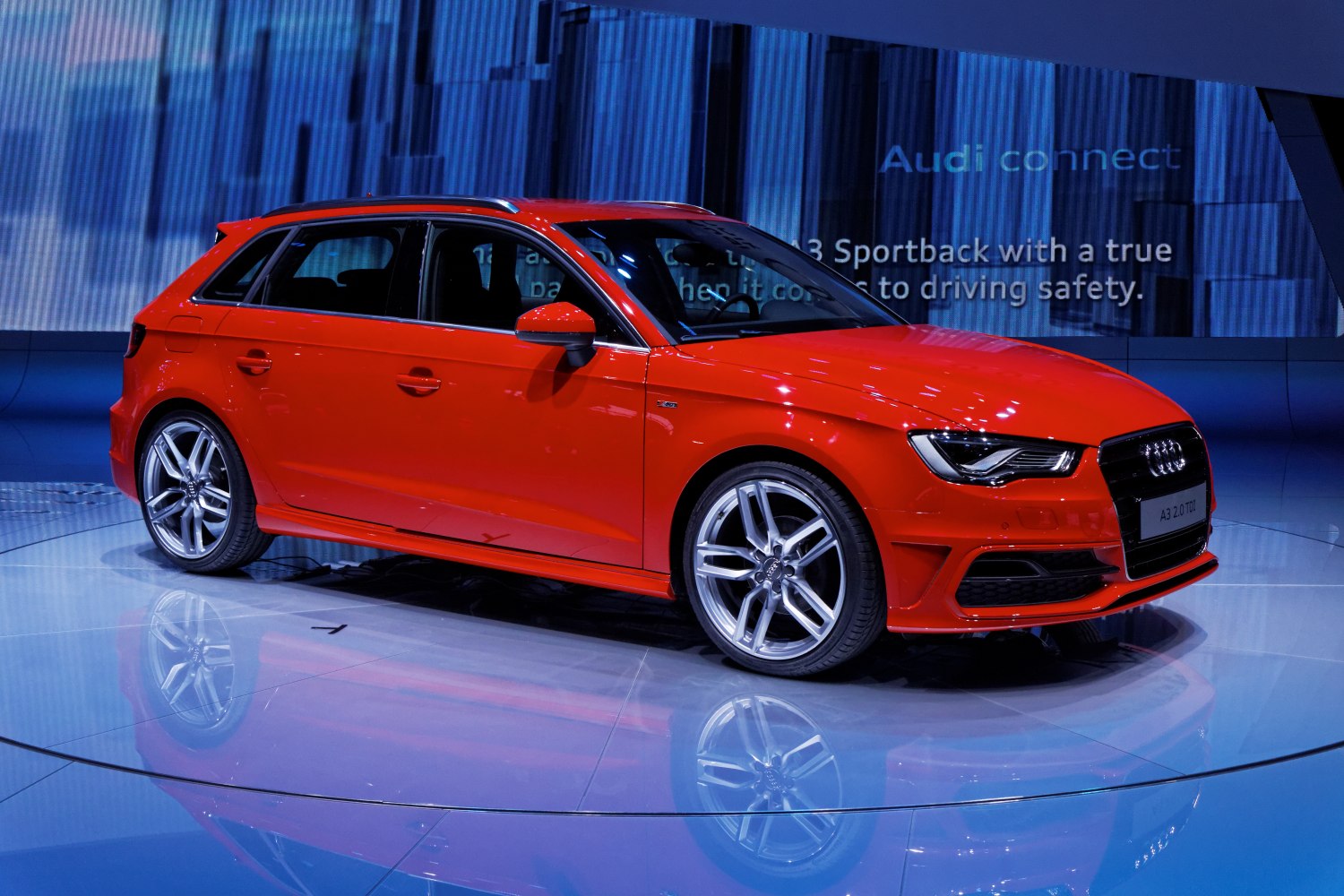 Red hatchback with sporty wheels and sleek front side design