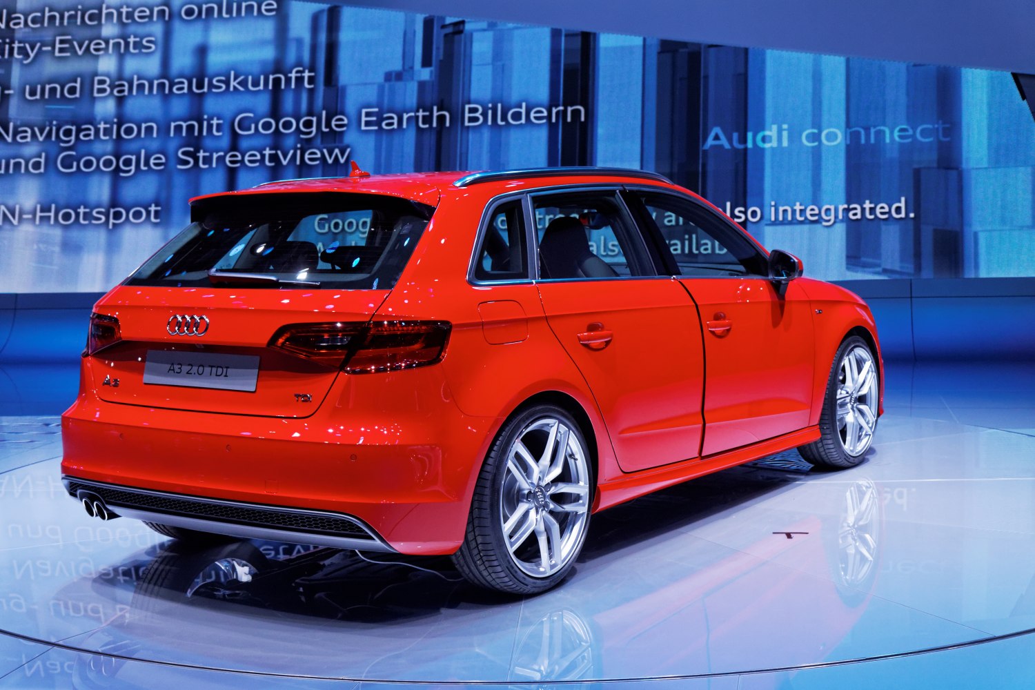 Rear side view of red hatchback with sporty alloy wheels and dual exhaust