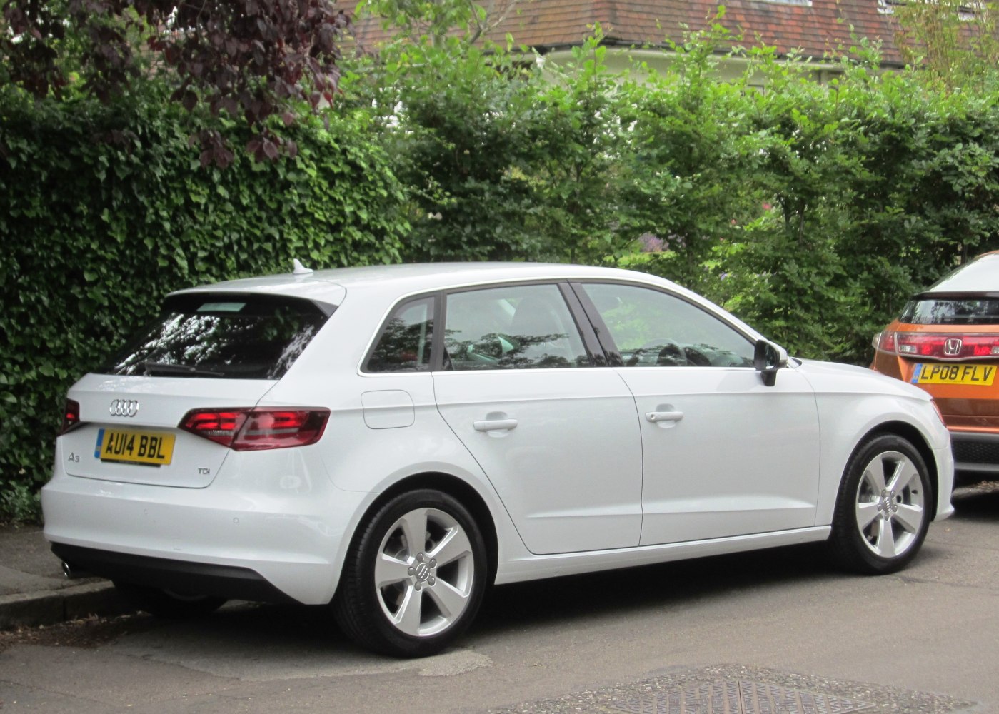 White compact hatchback with rear and side view, alloy wheels