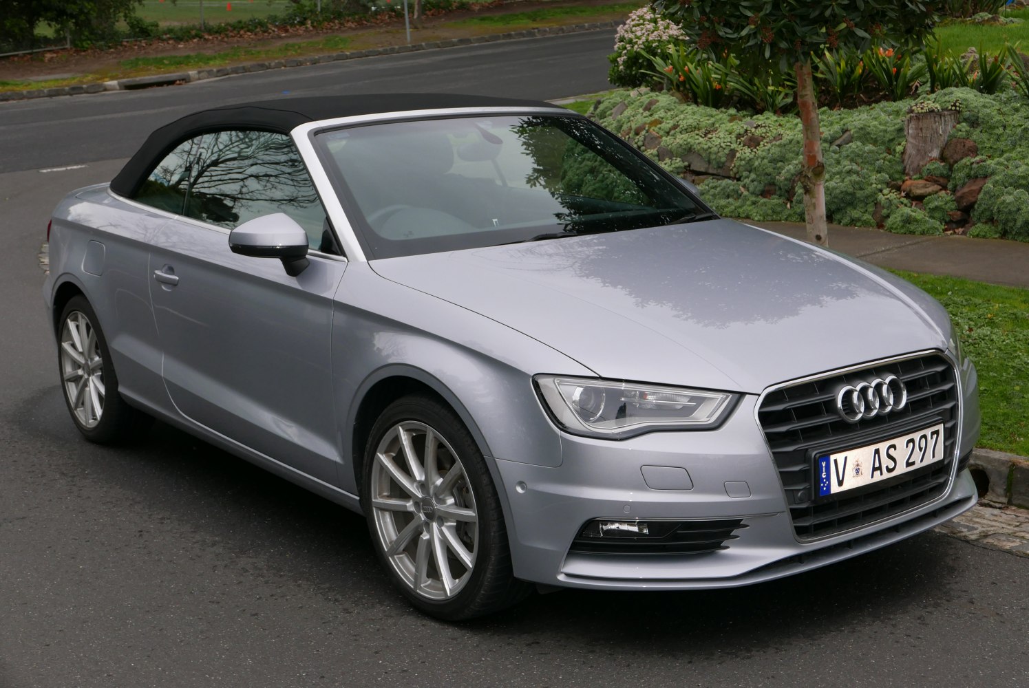 Silver convertible with black soft top and multi-spoke alloy wheels
