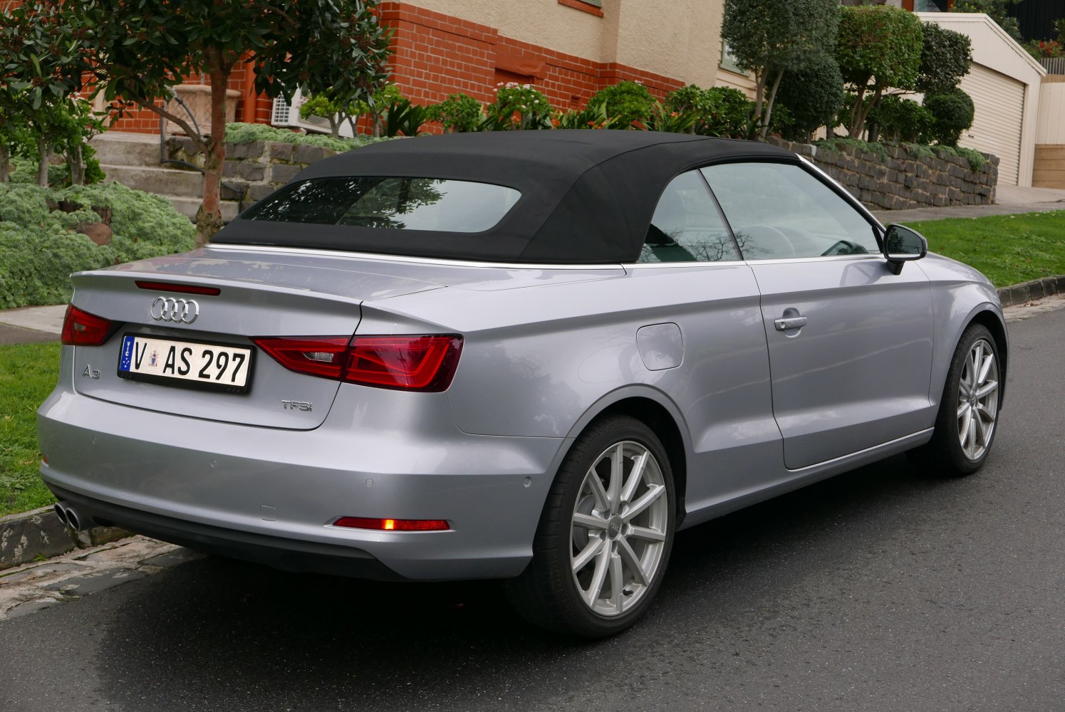 Rear and side view convertible with black soft-top roof and alloy wheels