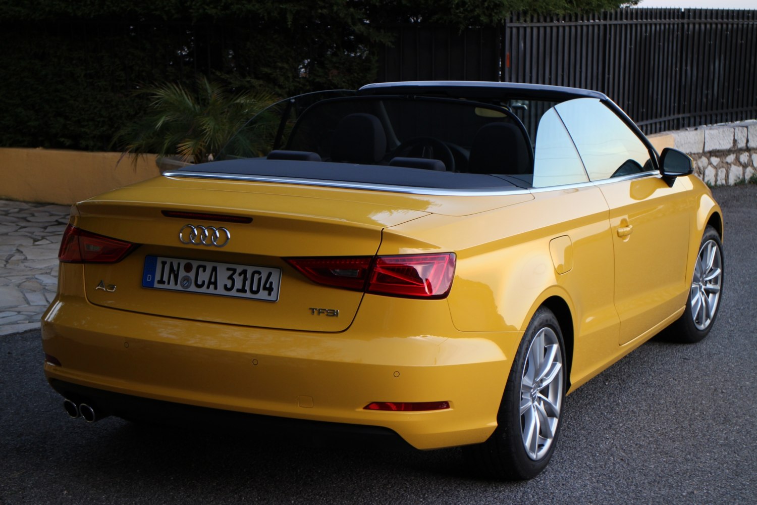 Yellow convertible rear view with dual exhaust and alloy wheels