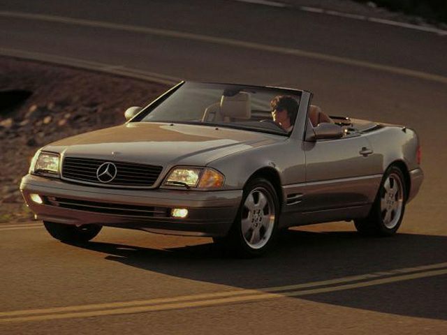 Convertible luxury roadster front view with headlights and grille.