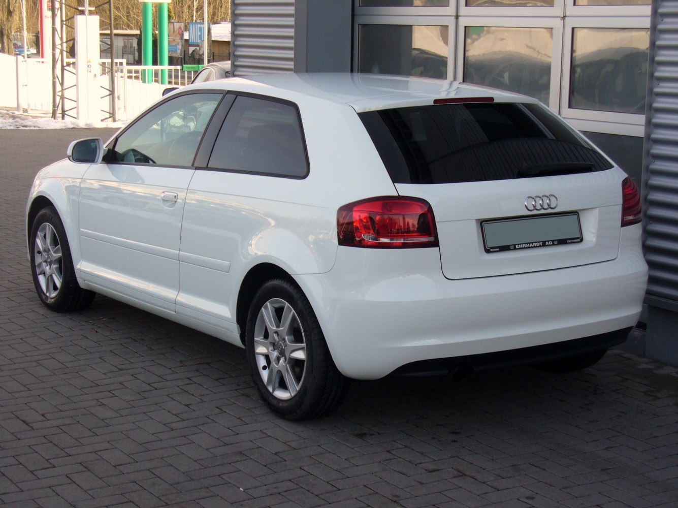 Rear-side view of a white compact hatchback with alloy wheels and tinted windows