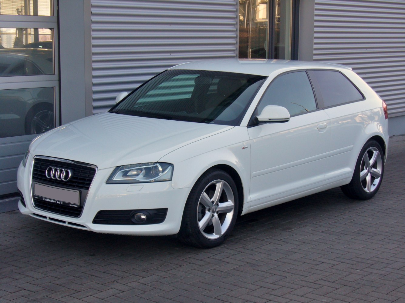 White hatchback with front-side view and alloy wheels