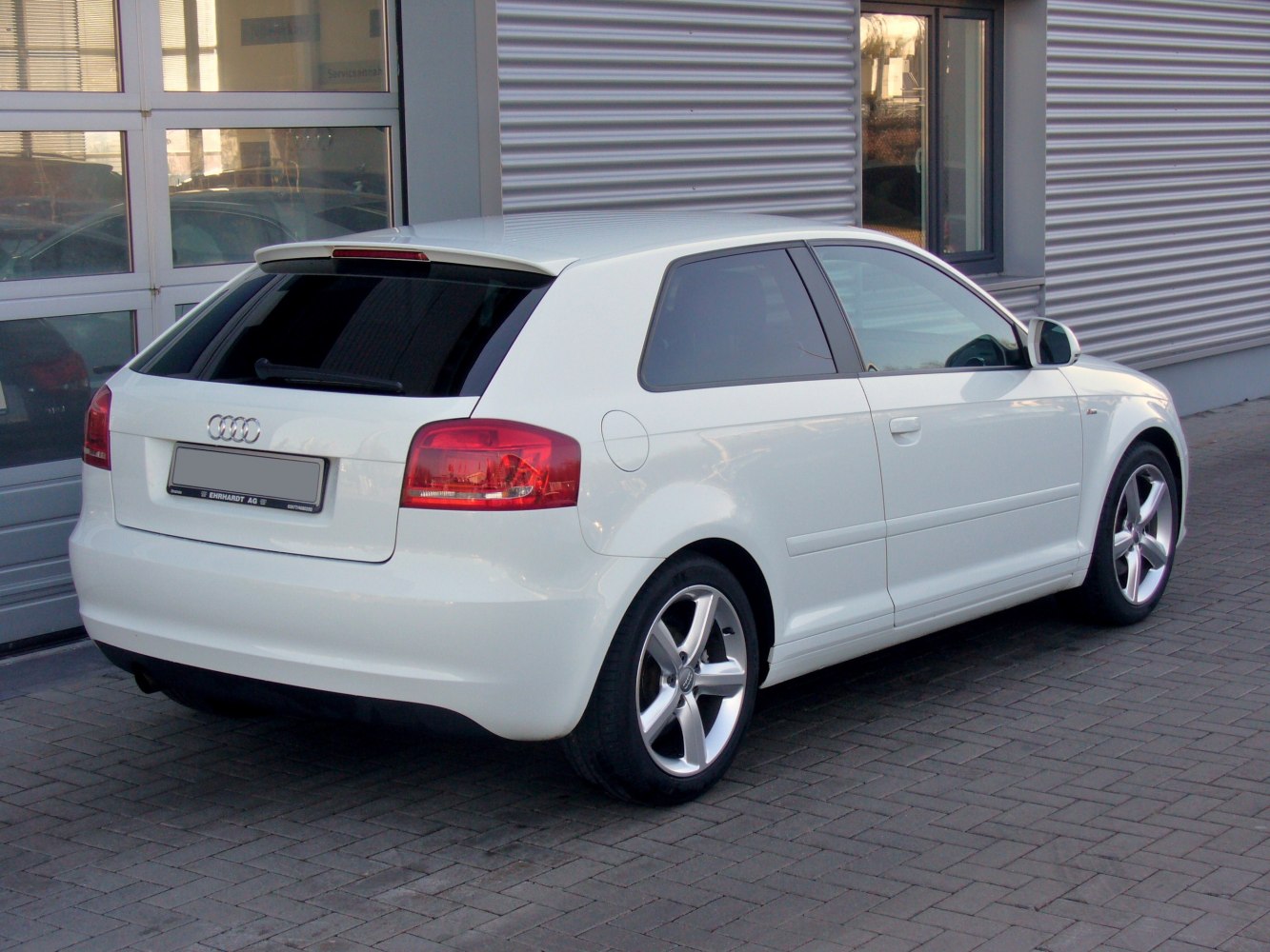 Rear and side view of a white hatchback with alloy wheels
