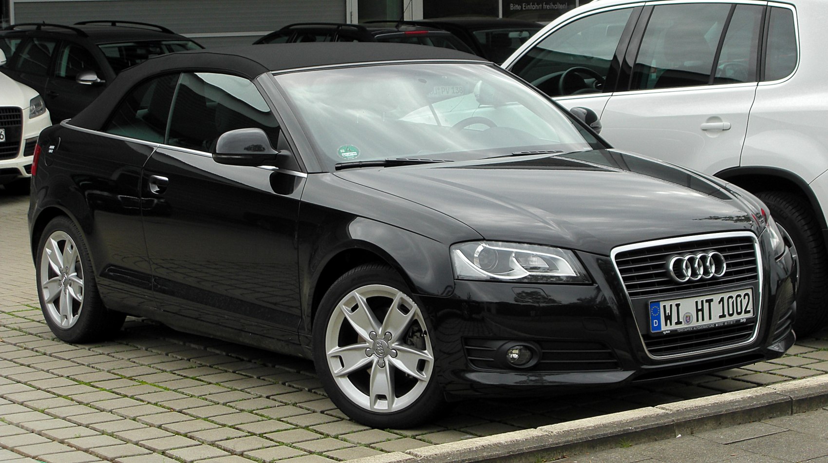 Black convertible with soft top roof and alloy wheels