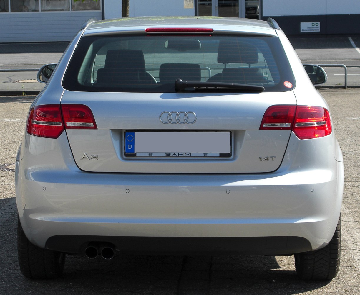 Rear view with tail lights, dual exhaust, badges, and rear wiper