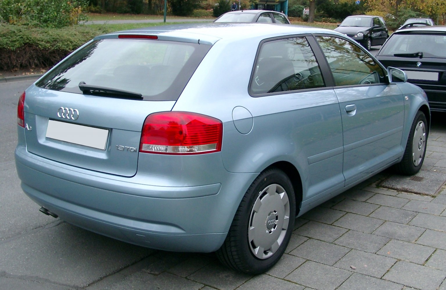 Rear-side light blue hatchback with distinct taillights and rear wiper