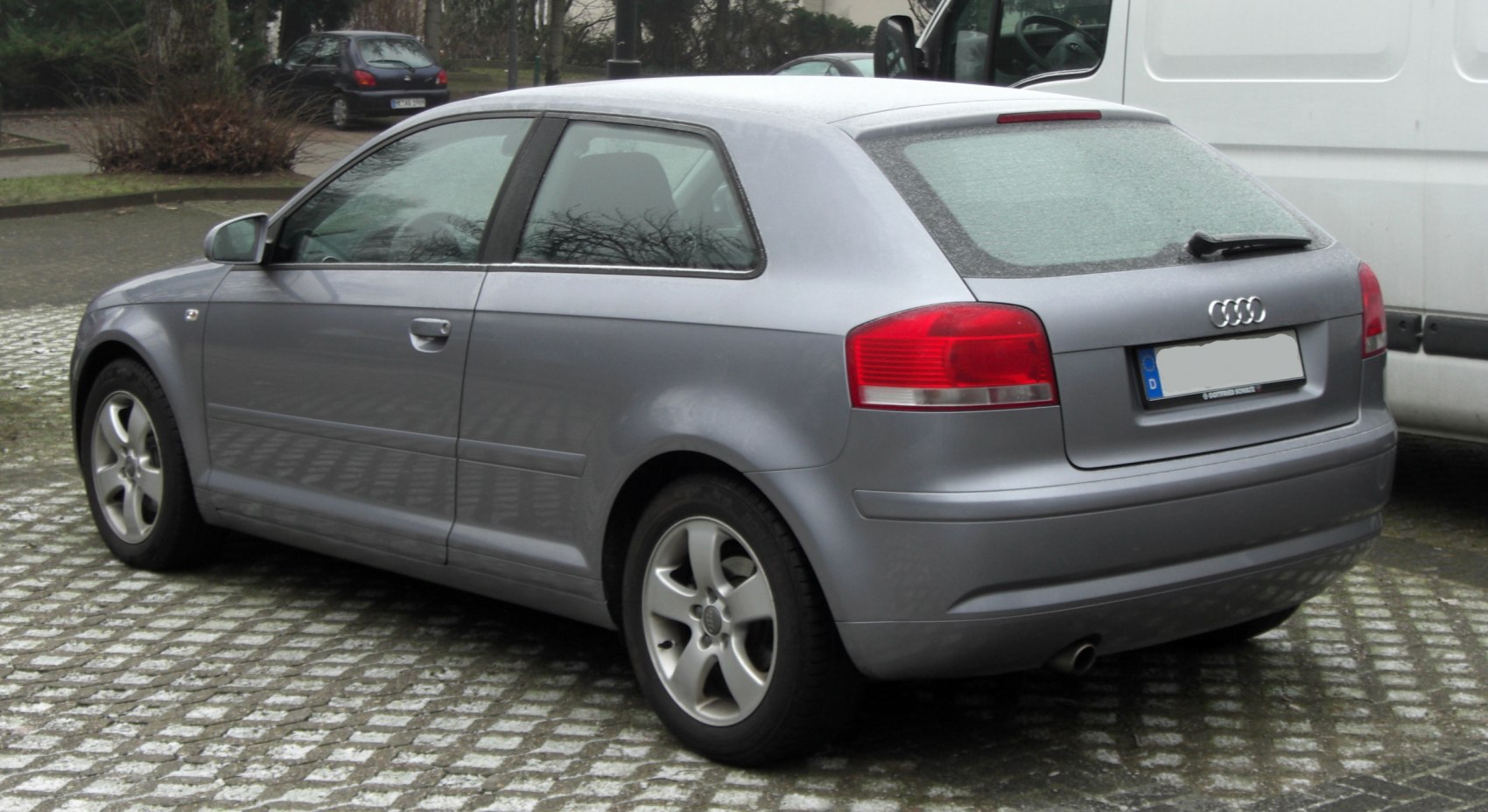 Rear side profile of a compact hatchback with alloy wheels