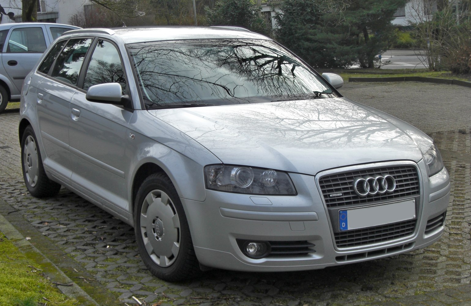 Front and side view of silver five-door hatchback with distinctive grille and rounded headlights