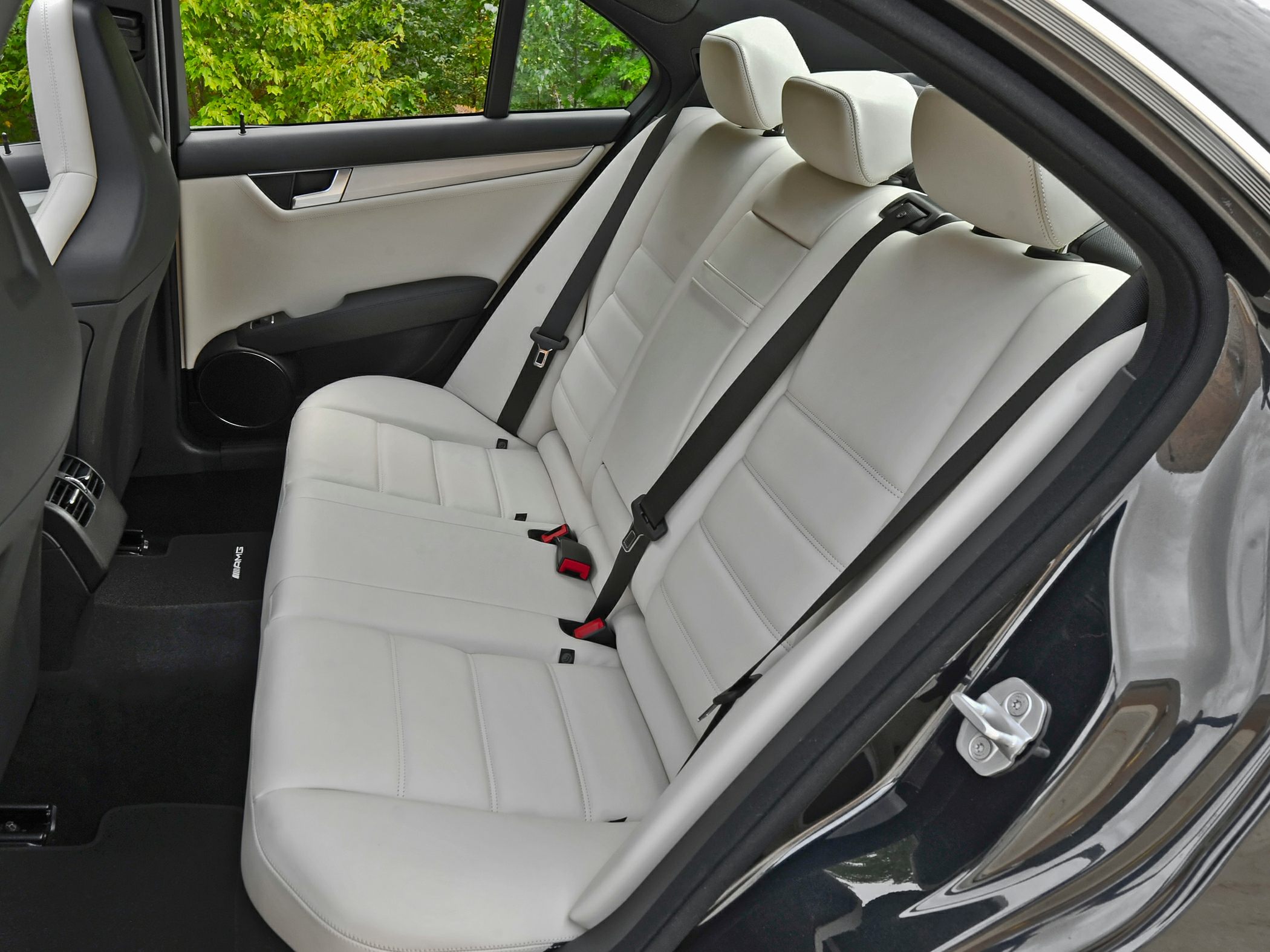 White leather rear seats with black seat belts in car interior