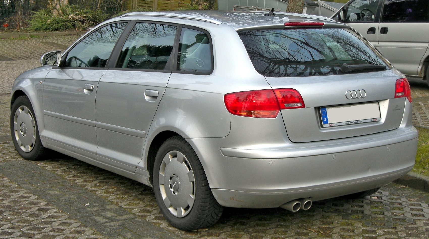 Silver hatchback rear side view with dual exhausts and distinct taillights