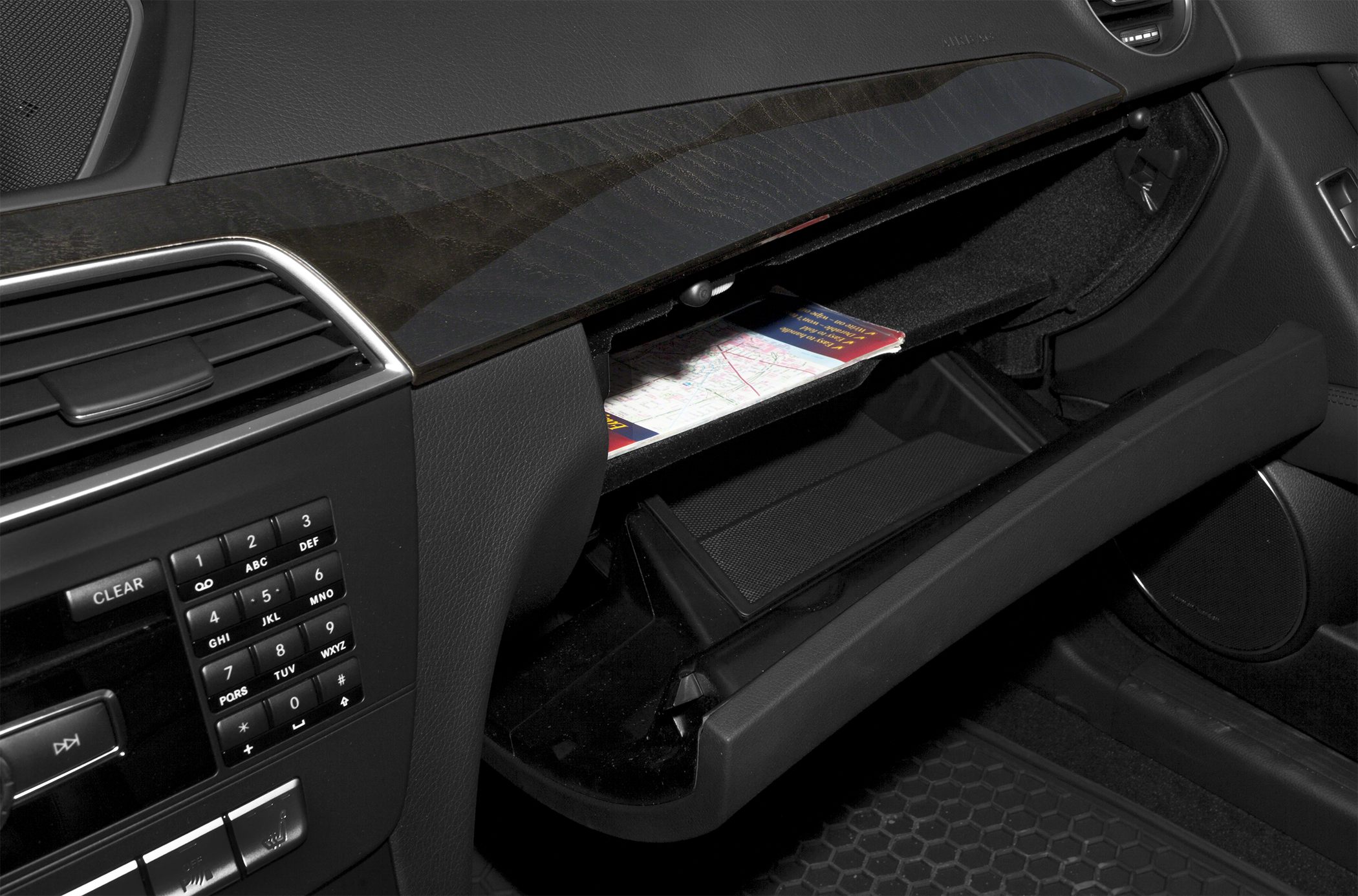 Open glove compartment with wooden dashboard trim and control panel keypad