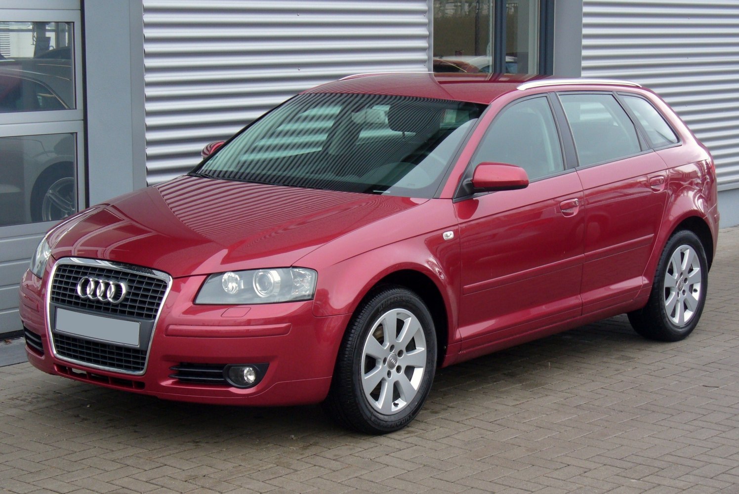 Red hatchback with alloy wheels and clear headlights
