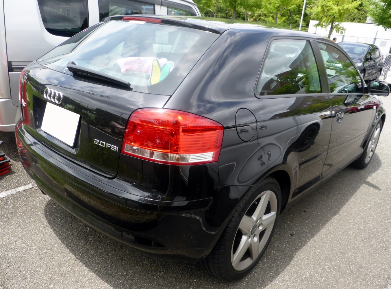 Rear and side view of black hatchback with distinctive tail lights