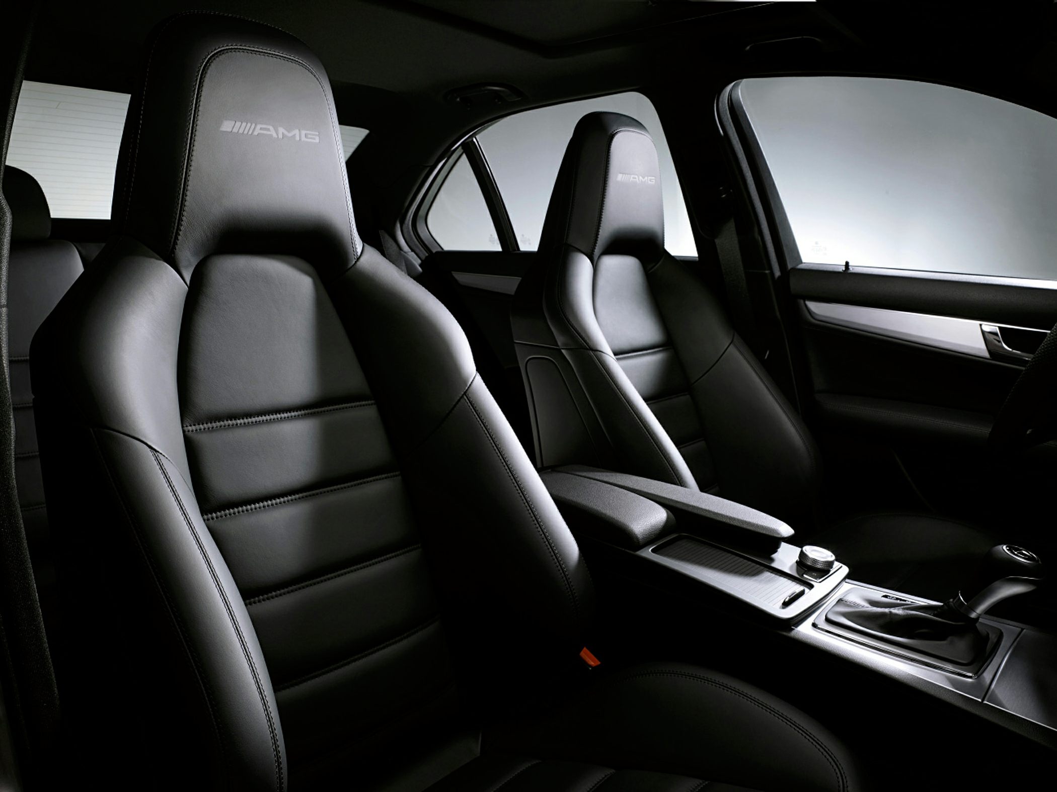 AMG branded leather sport seats with modern center console inside a car interior.