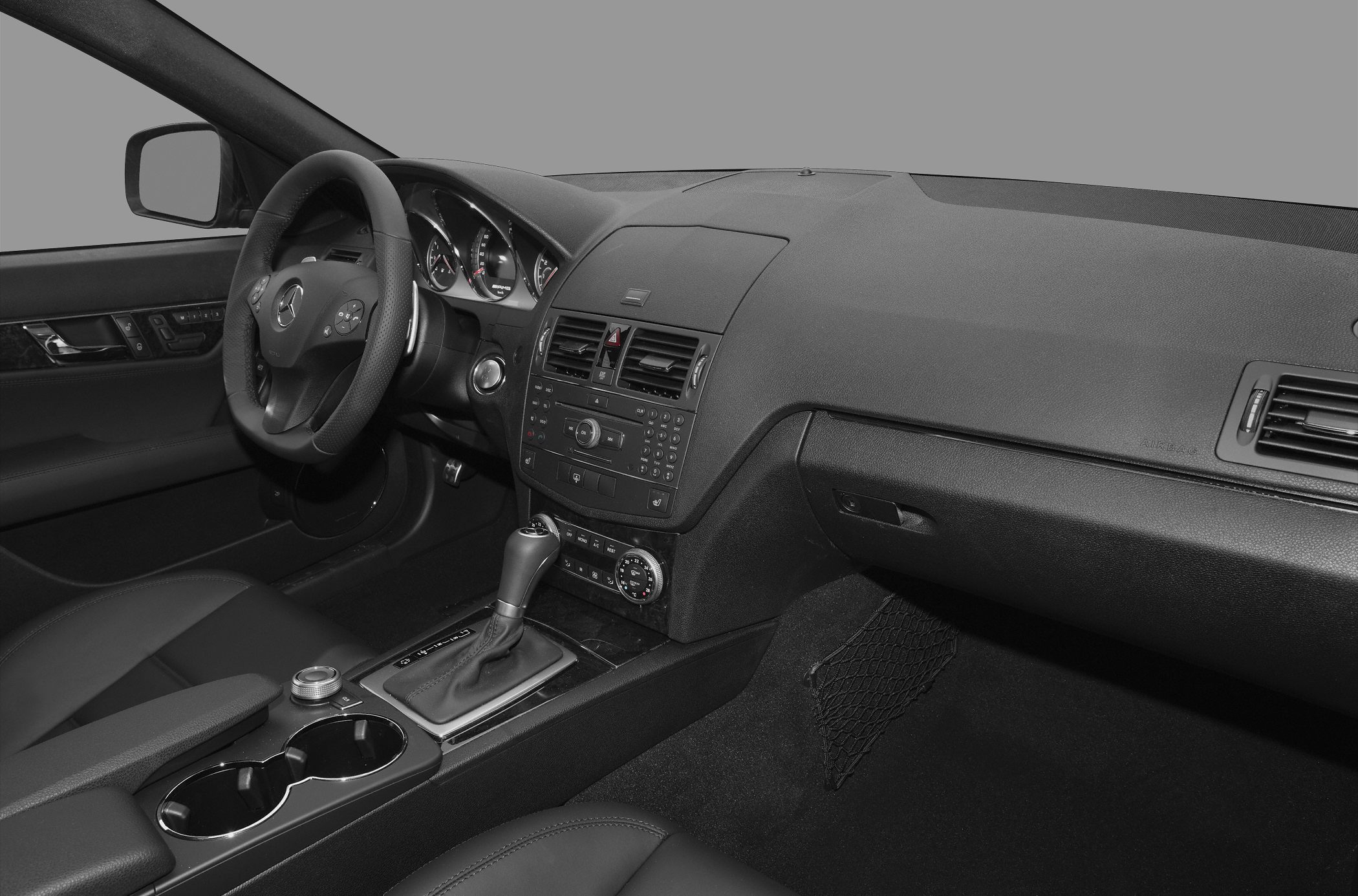 Dashboard and steering wheel with center console and gear shifter.