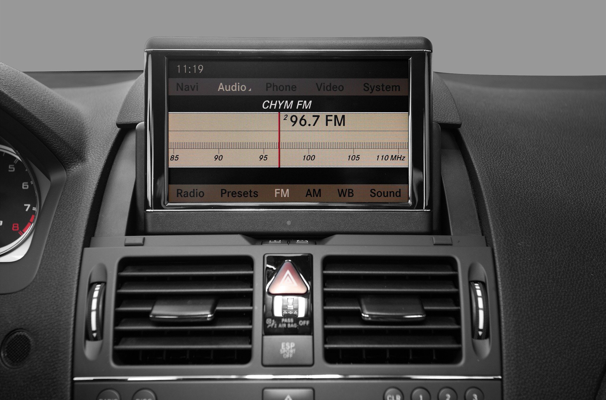 Multimedia display with radio interface and central dashboard air vents.