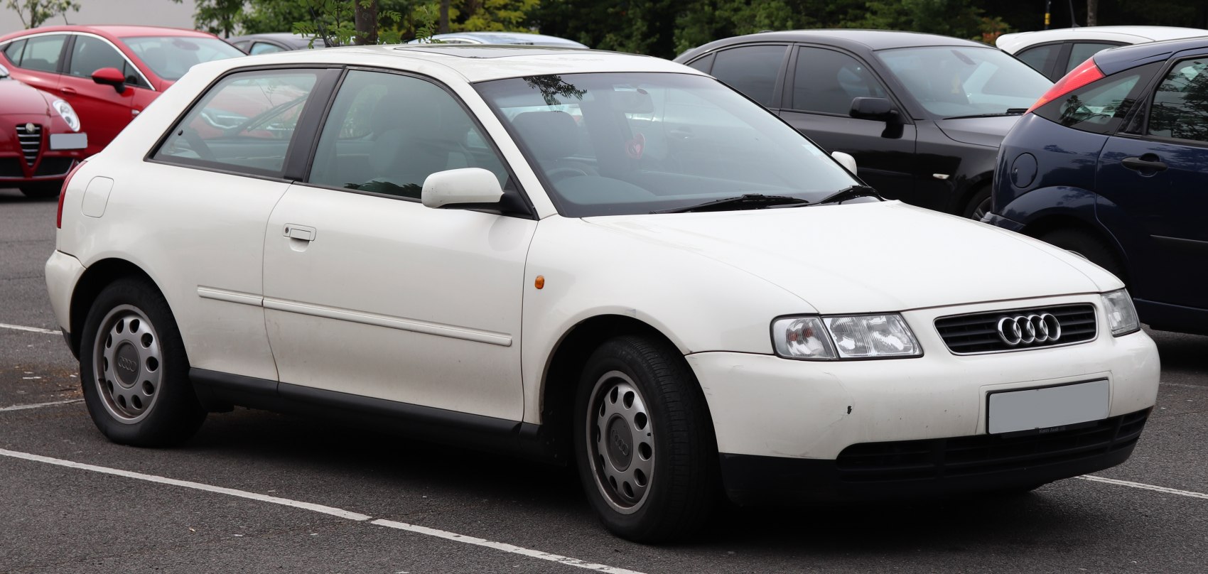 White compact hatchback with slanted rectangular headlights and horizontal grille