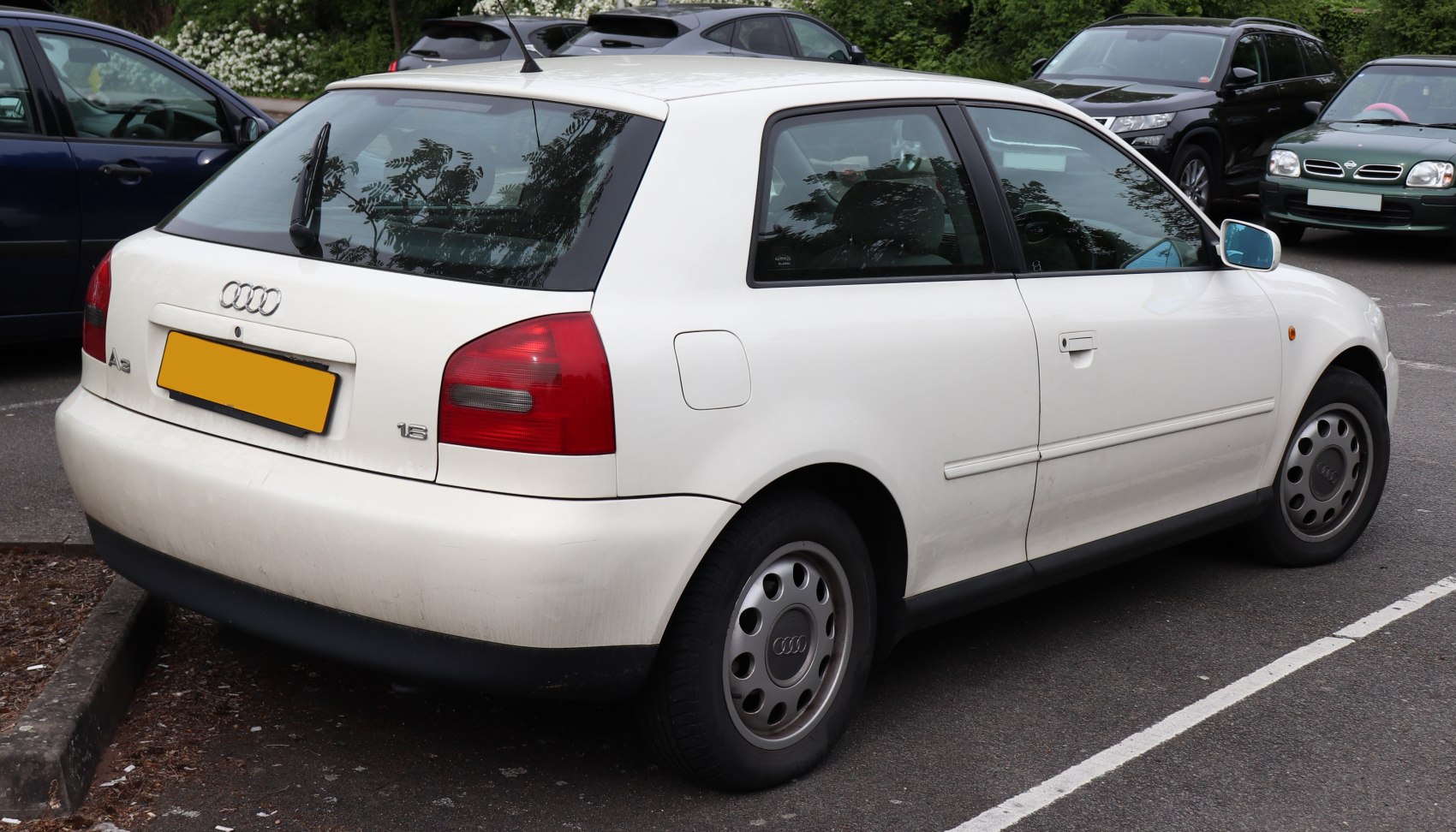Rear and side view of a white hatchback with rear wiper and rounded tail lights