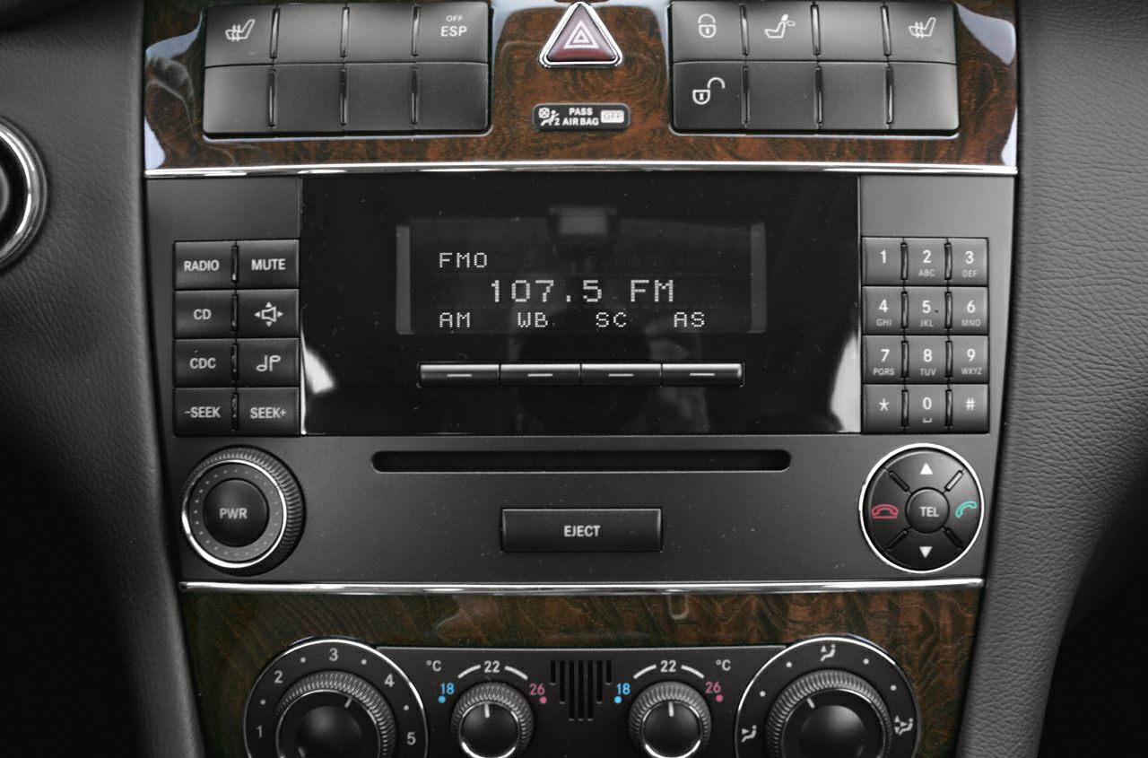 Audio and climate control panel of a car interior with radio and temperature dials.