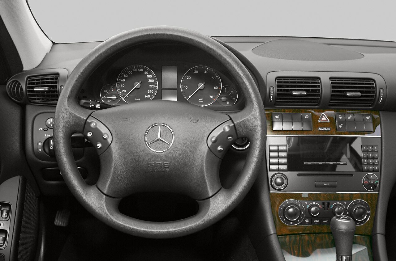 Dashboard and steering wheel with controls and wood trim