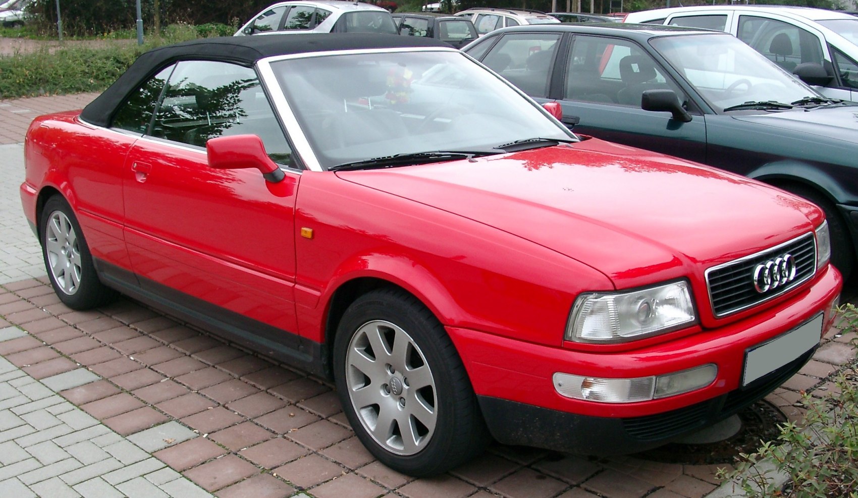 Red convertible with black soft top and silver alloy wheels
