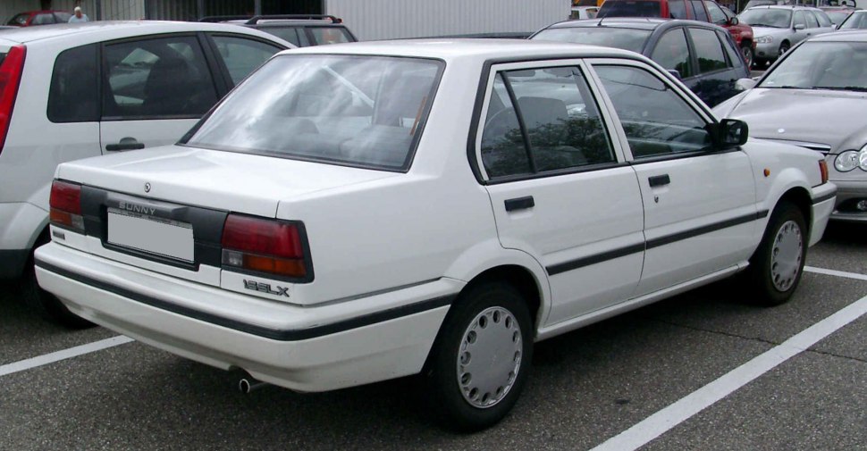 White four-door sedan rear side view with taillights and classic body lines.