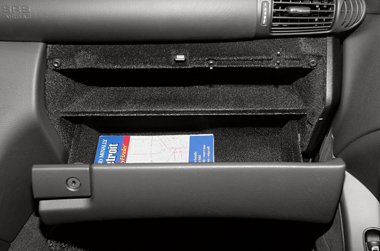 Spacious glovebox storage compartment with textured interior lining and key lock.