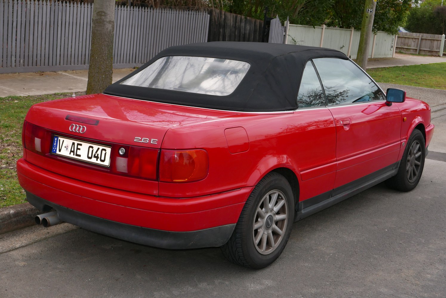 Red convertible with black soft top and rear view