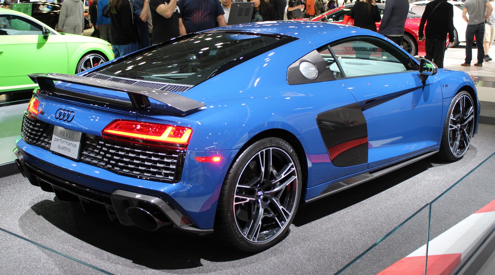 Rear view of a blue sports coupe with carbon fiber rear spoiler