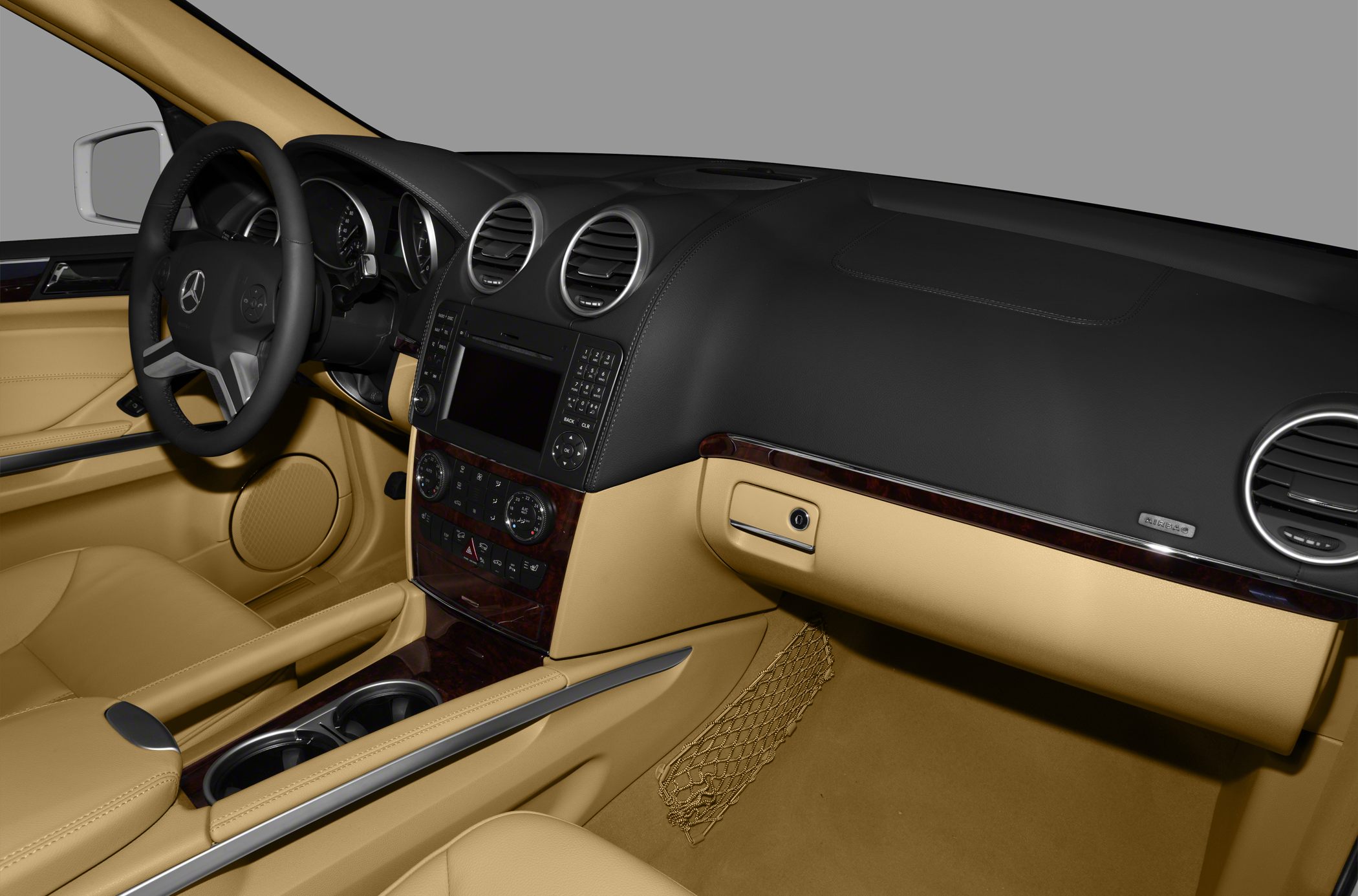 Luxury SUV interior with beige leather, dual round vents, and modern dashboard