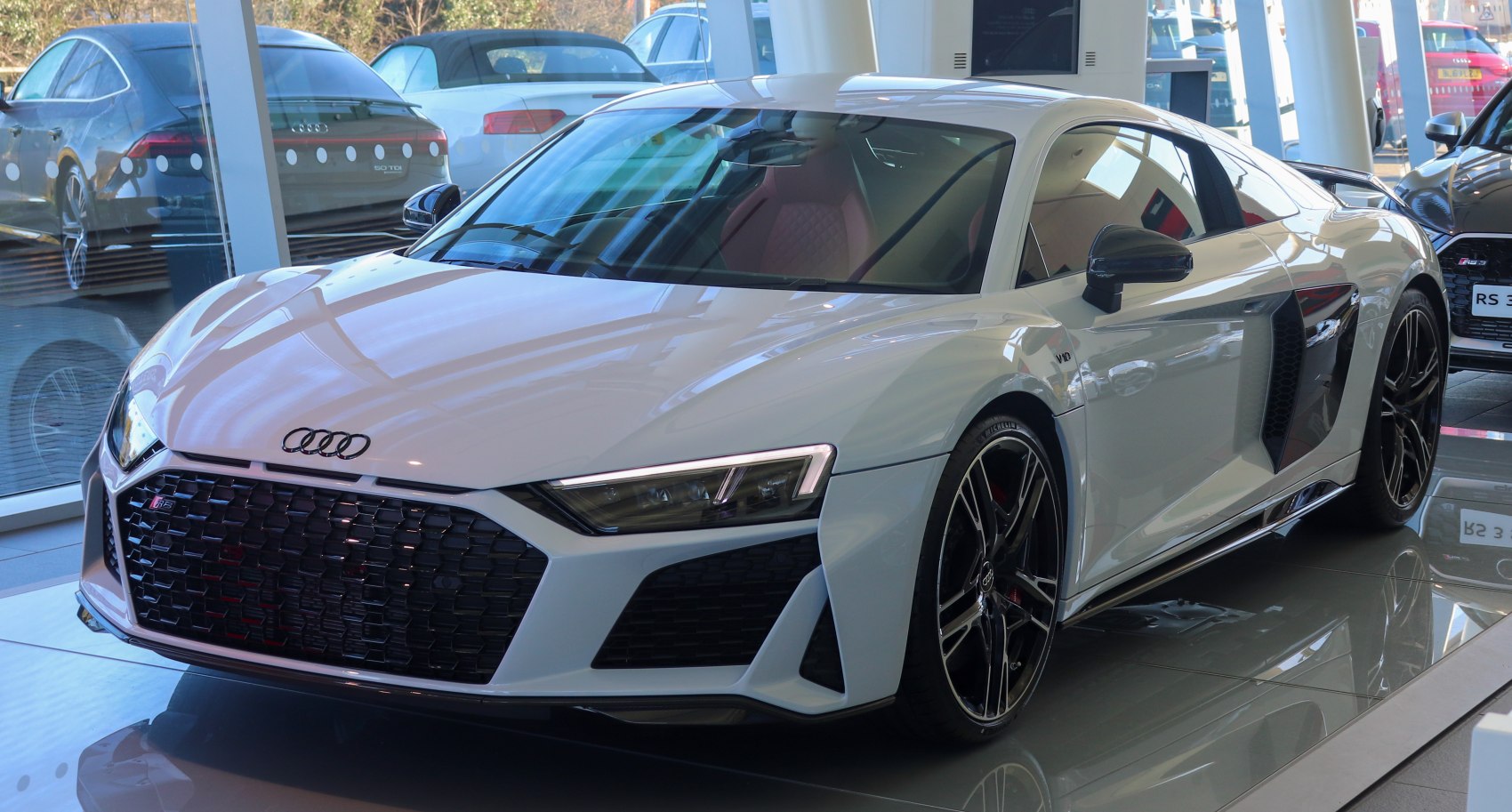 Front grille and sporty side profile of a white luxury coupe.