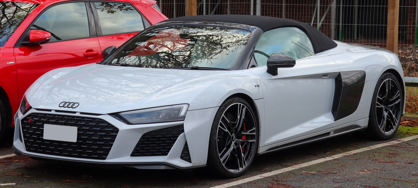 Convertible sports car with honeycomb grille and black soft top