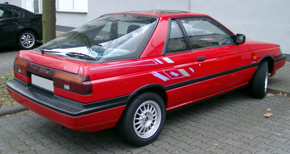 Rear and side profile of a red coupe with decals and alloy wheels