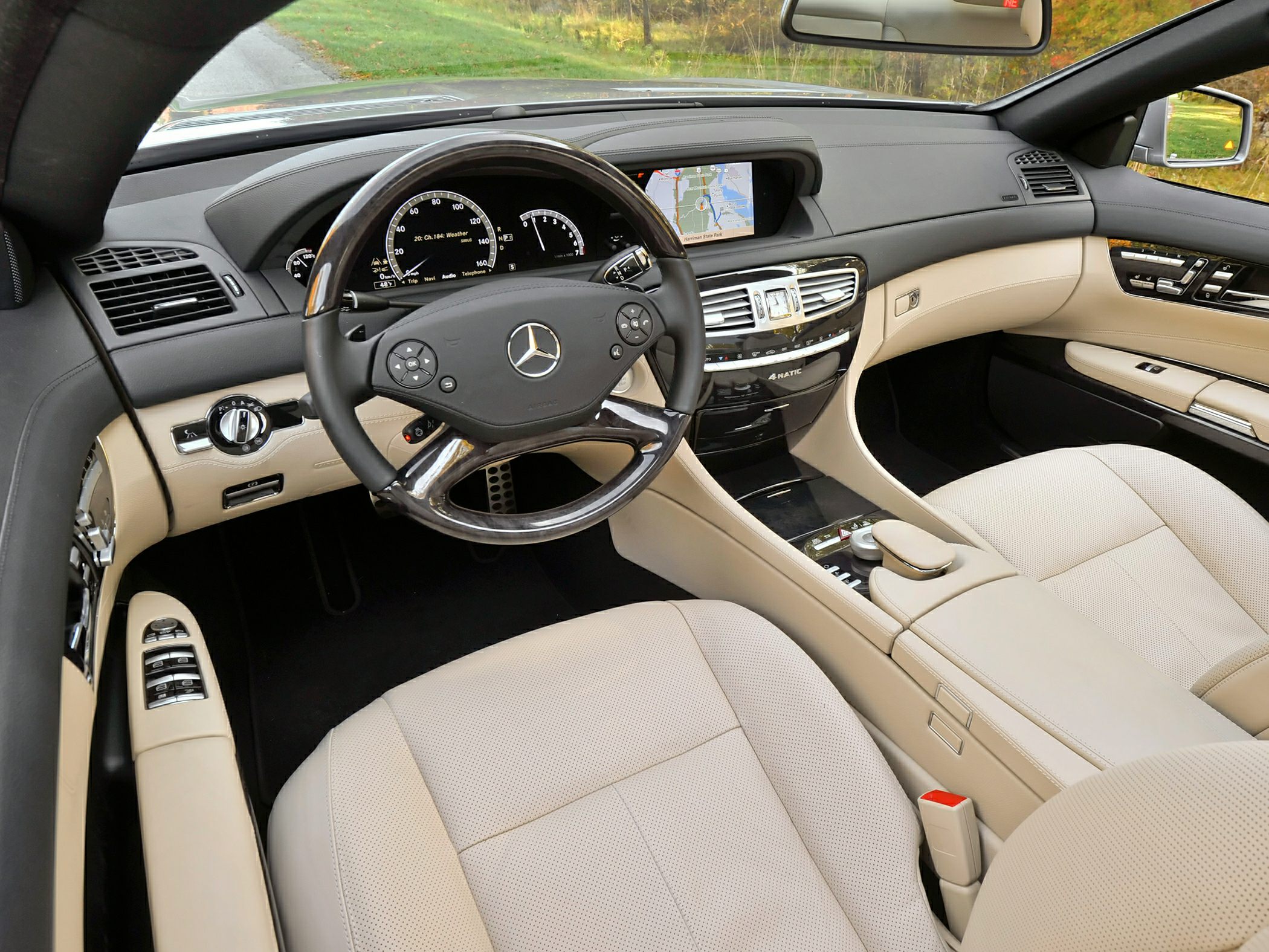 Beige leather seats and wood trim steering wheel with digital dashboard